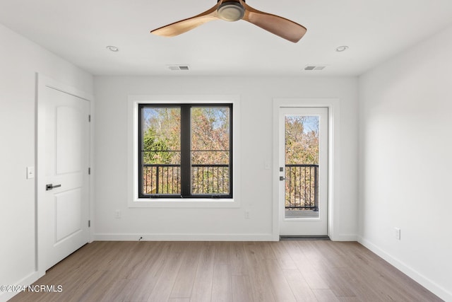 spare room with ceiling fan and light wood-type flooring