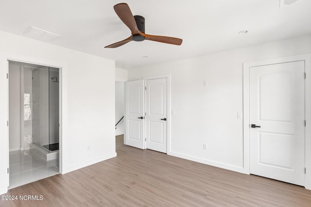 unfurnished bedroom featuring light wood-type flooring, ceiling fan, and connected bathroom