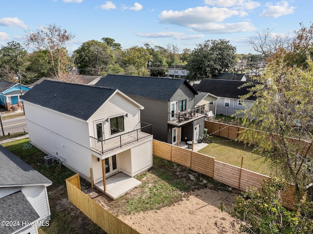 back of property featuring french doors, a patio, a balcony, and a lawn