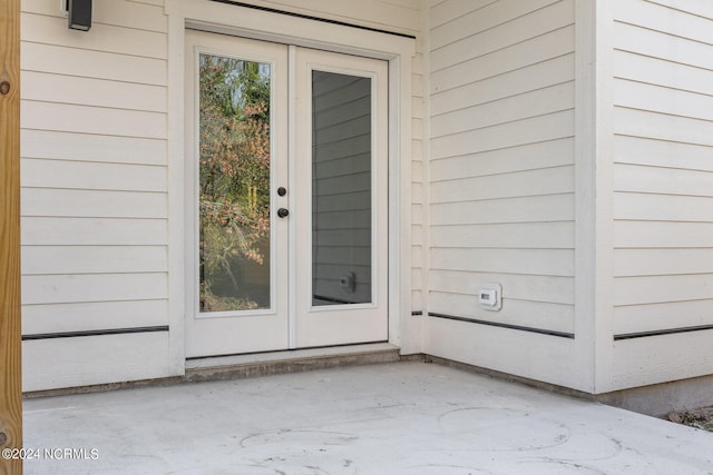 view of exterior entry with a patio area