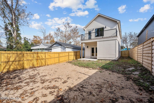 rear view of house featuring french doors and a balcony