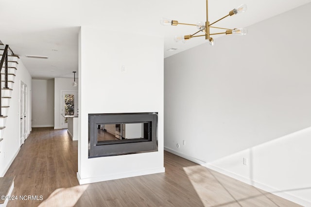 unfurnished living room with a chandelier and hardwood / wood-style flooring