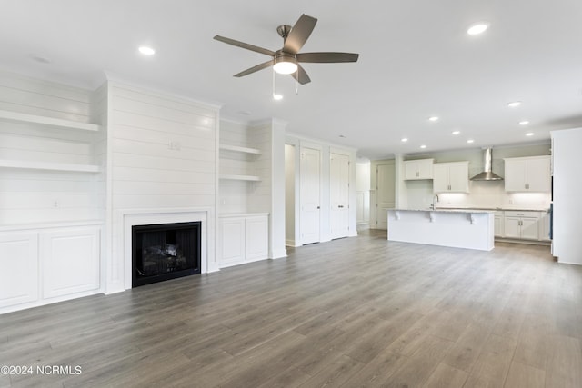 2058 Greenside Manor Dr, Ocean Isle Beach, NC 28469 - unfurnished living room with wood finished floors, a sink, ceiling fan, a fireplace, and recessed lighting