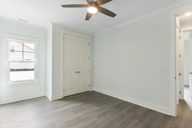 2058 Greenside Manor Dr, Ocean Isle Beach, NC 28469 - unfurnished bedroom featuring visible vents, a closet, crown molding, baseboards, and dark wood-style flooring