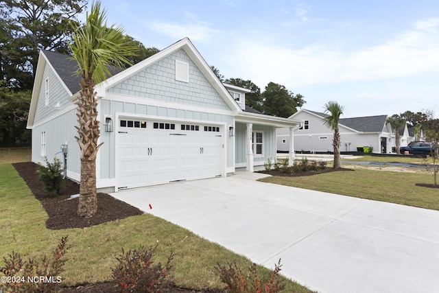 2058 Greenside Manor Dr, Ocean Isle Beach, NC 28469 - view of front of house with concrete driveway, a front lawn, board and batten siding, and a garage