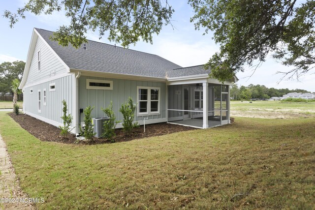 2058 Greenside Manor Dr, Ocean Isle Beach, NC 28469 - rear view of property with a lawn, a sunroom, and roof with shingles