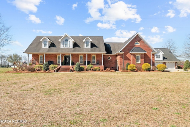 cape cod home with a front lawn, covered porch, and a garage