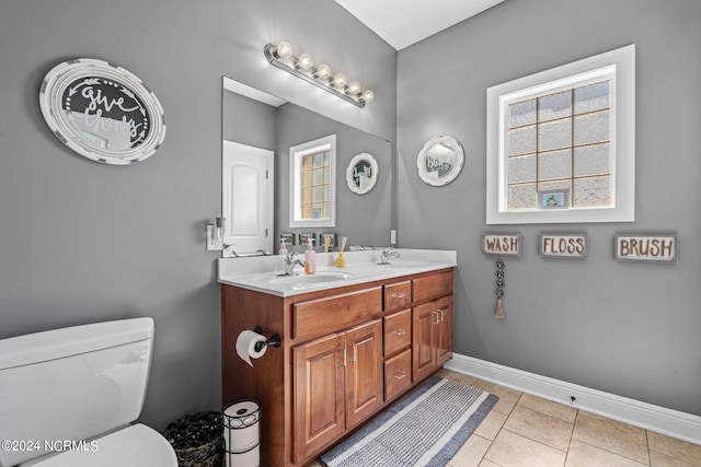 bathroom featuring dual bowl vanity, tile flooring, and toilet