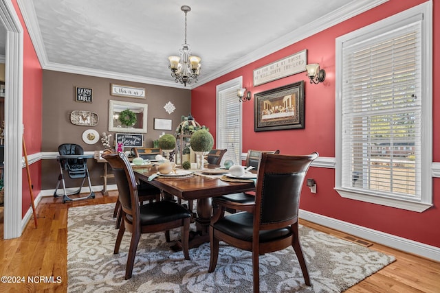 dining room featuring crown molding, a notable chandelier, and light hardwood / wood-style flooring