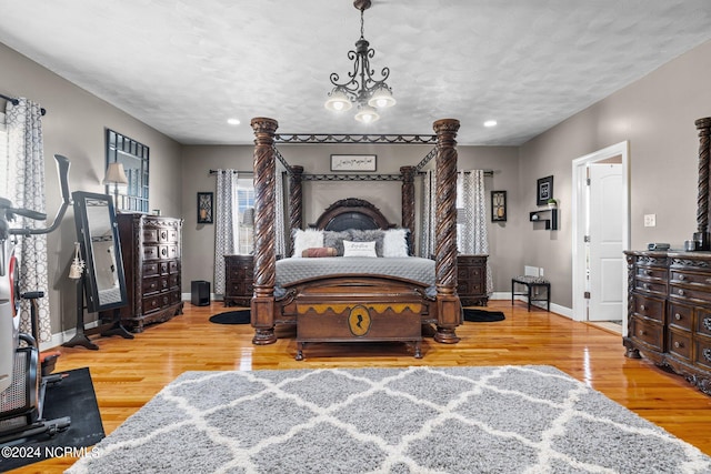 bedroom with a chandelier and light hardwood / wood-style floors