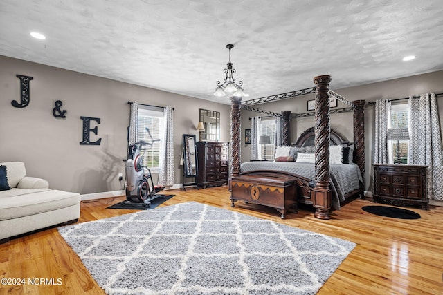 bedroom featuring a textured ceiling, multiple windows, and light wood-type flooring