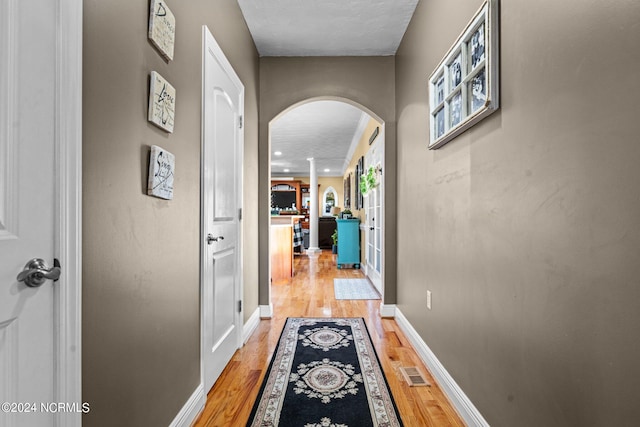 corridor featuring light hardwood / wood-style flooring and a textured ceiling