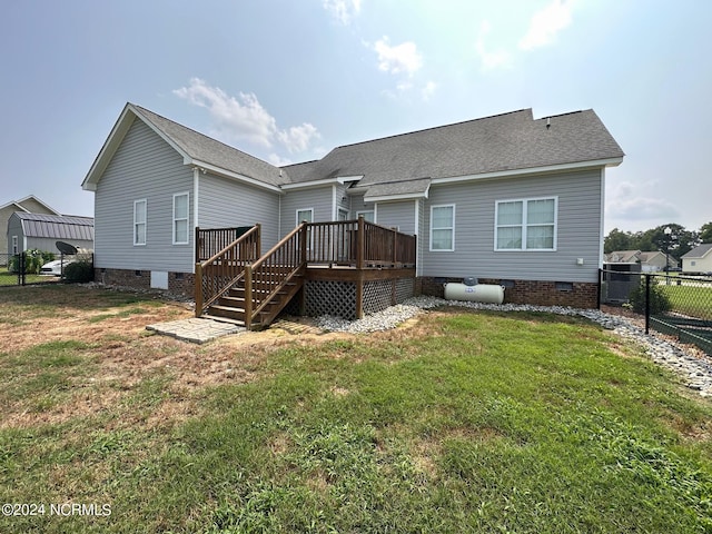 rear view of house with a yard, a carport, and a wooden deck