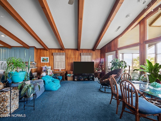 living room with carpet flooring, vaulted ceiling with beams, and wood walls