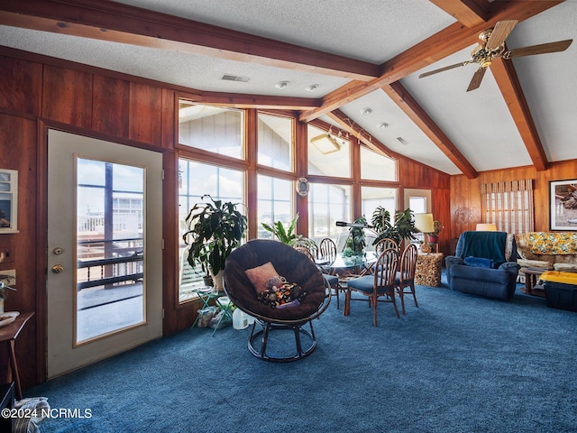 sunroom / solarium featuring a wealth of natural light, ceiling fan, and vaulted ceiling with beams