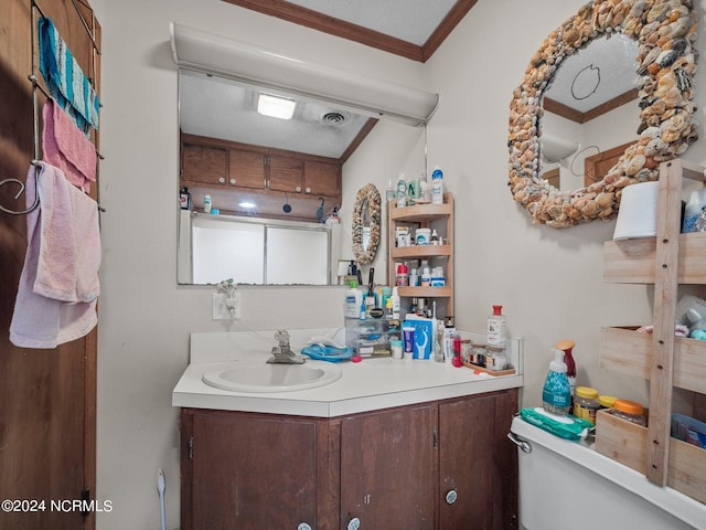 bathroom with vanity, toilet, ornamental molding, and a textured ceiling