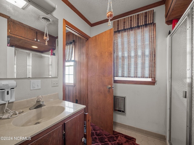 bathroom with vanity, crown molding, a textured ceiling, and walk in shower