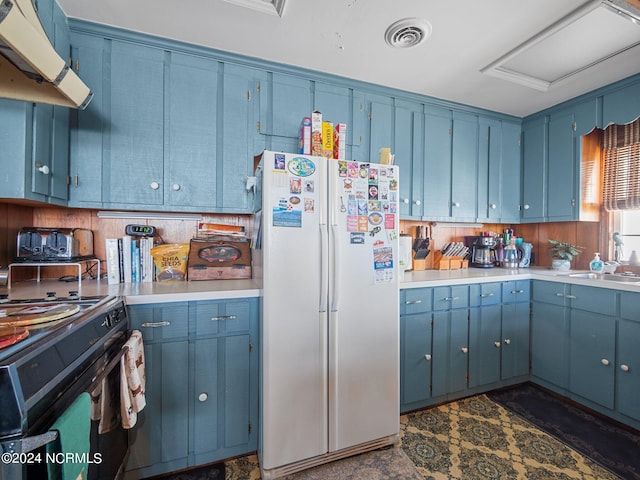 kitchen with blue cabinetry, white refrigerator, ventilation hood, and sink