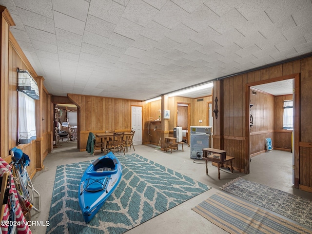 living room with concrete flooring and wooden walls