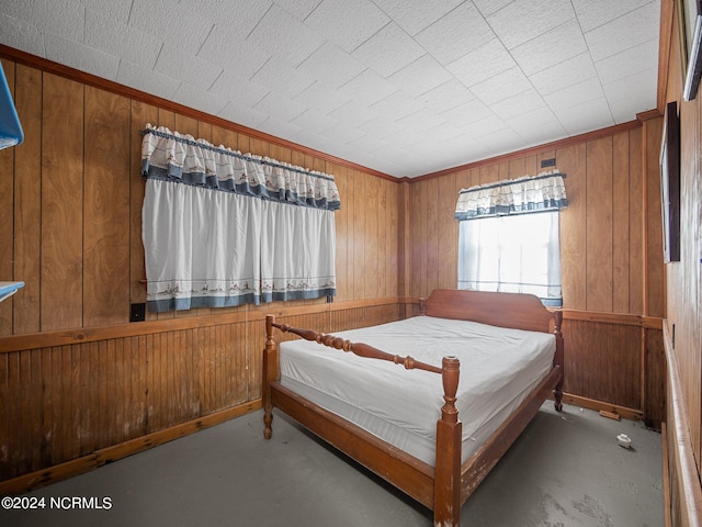 unfurnished bedroom featuring wood walls and crown molding