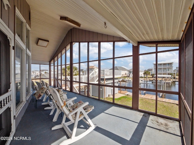 unfurnished sunroom with a water view, a wealth of natural light, and vaulted ceiling