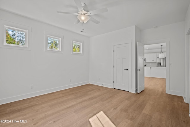 4865 Scarlet Sage Way, Shallotte, NC 28470 - unfurnished bedroom with stainless steel refrigerator with ice dispenser, multiple windows, light wood finished floors, and a ceiling fan