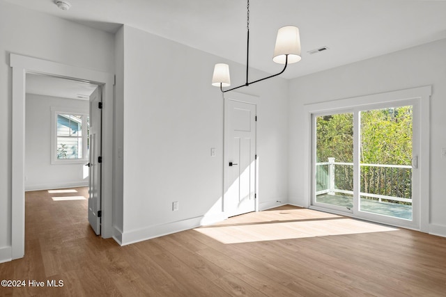 4865 Scarlet Sage Way, Shallotte, NC 28470 - unfurnished dining area featuring wood finished floors and a chandelier