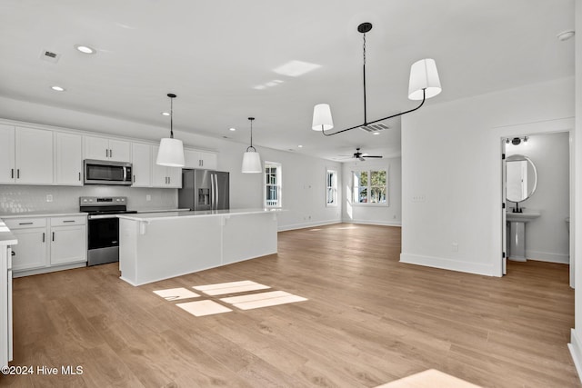 4865 Scarlet Sage Way, Shallotte, NC 28470 - kitchen featuring appliances with stainless steel finishes, recessed lighting, light countertops, backsplash, and a center island
