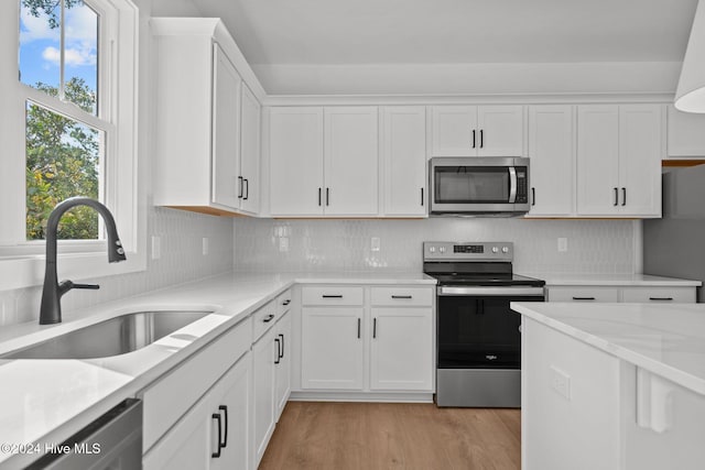 4865 Scarlet Sage Way, Shallotte, NC 28470 - kitchen featuring appliances with stainless steel finishes, light wood-style flooring, white cabinetry, and tasteful backsplash