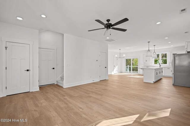4865 Scarlet Sage Way, Shallotte, NC 28470 - unfurnished living room with light wood-type flooring, recessed lighting, ceiling fan, and stairs