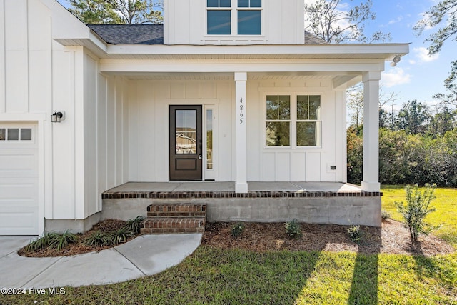 4865 Scarlet Sage Way, Shallotte, NC 28470 - doorway to property featuring covered porch, board and batten siding, a shingled roof, and a garage