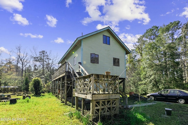 back of property featuring a wooden deck and a yard