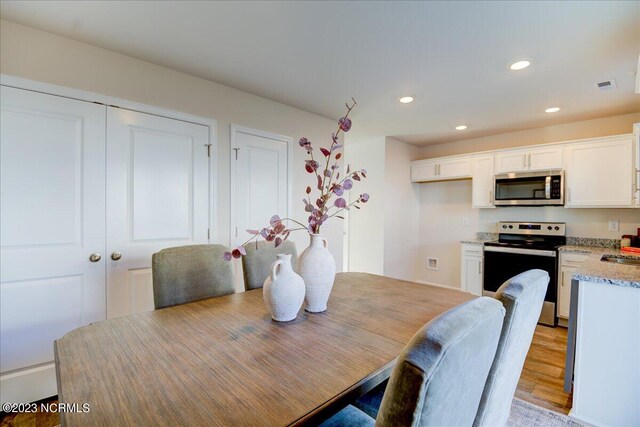 dining room featuring light wood-style floors, visible vents, and recessed lighting