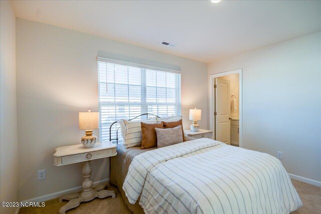 bedroom with baseboards, visible vents, and light colored carpet