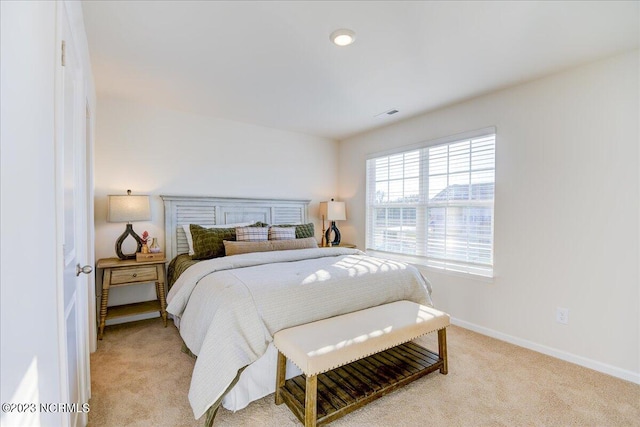 bedroom featuring light carpet and baseboards