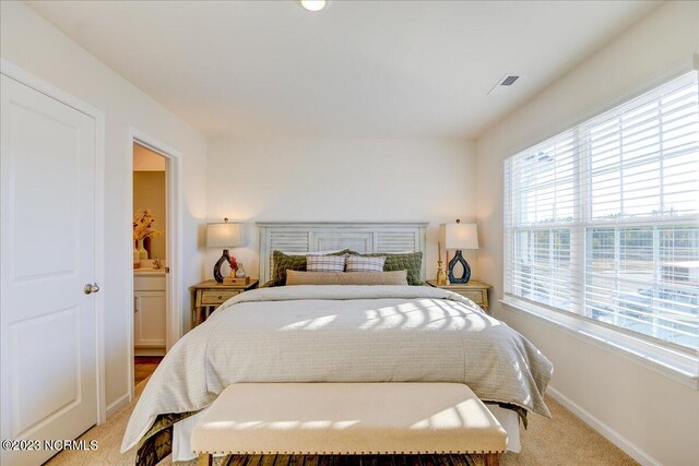 bedroom with light colored carpet, visible vents, and baseboards