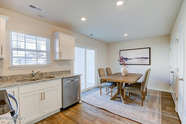 kitchen with visible vents, a sink, light wood finished floors, and stainless steel dishwasher