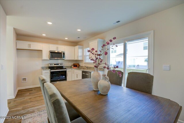 dining area featuring visible vents, baseboards, light wood-style flooring, and recessed lighting