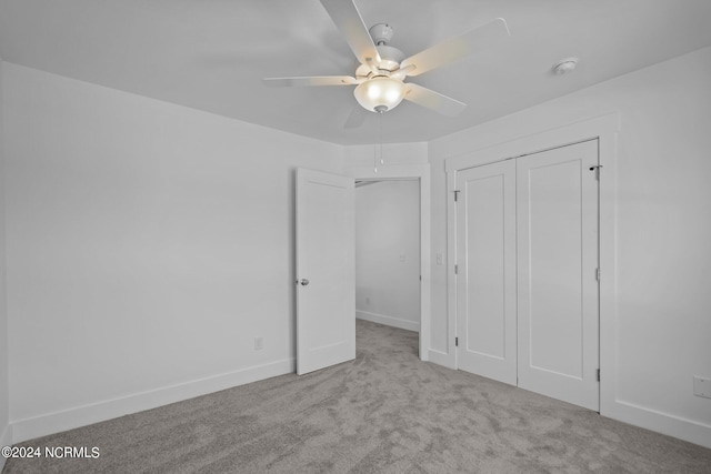 unfurnished bedroom with a closet, carpet flooring, ceiling fan, and baseboards