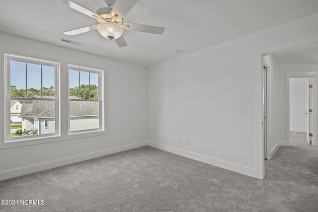 spare room featuring a healthy amount of sunlight, visible vents, and carpet flooring