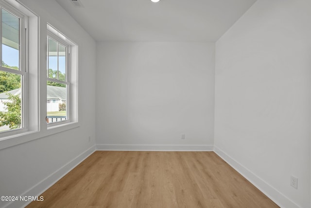 empty room featuring light wood-type flooring and baseboards