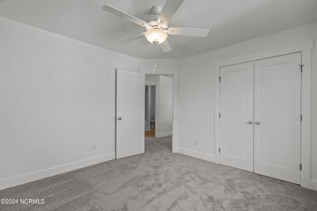 unfurnished bedroom featuring carpet, a closet, ceiling fan, and baseboards