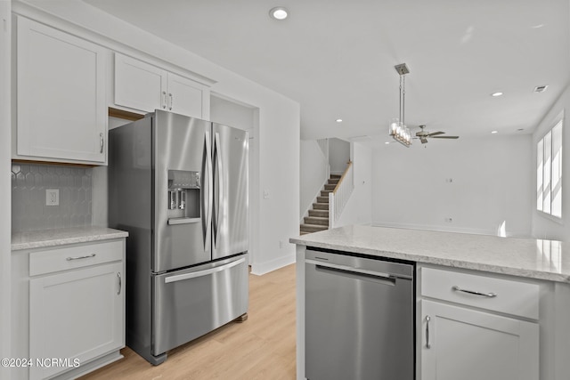 kitchen with recessed lighting, white cabinetry, appliances with stainless steel finishes, light wood finished floors, and tasteful backsplash