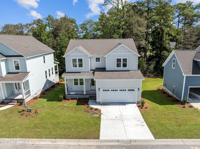 view of front of house featuring driveway, roof with shingles, an attached garage, a front lawn, and board and batten siding