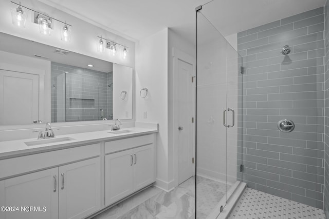 full bathroom featuring double vanity, a stall shower, and a sink