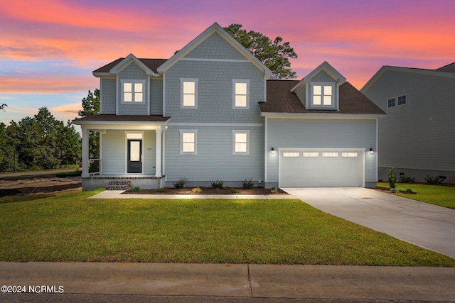 view of front of home with an attached garage, covered porch, a yard, driveway, and roof with shingles