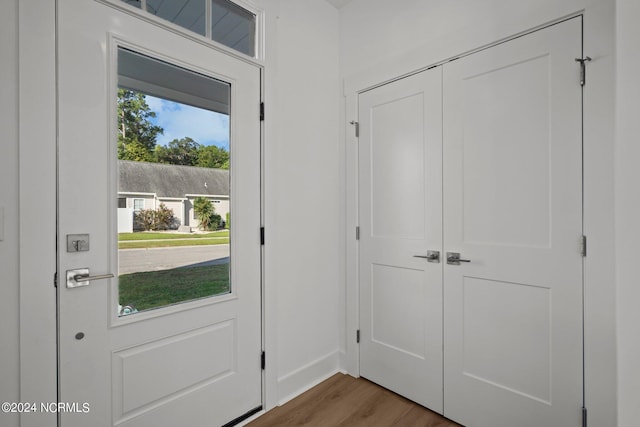 doorway featuring wood finished floors and baseboards