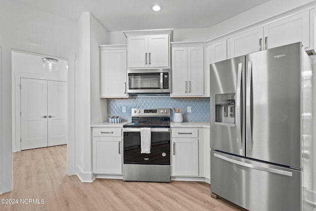 kitchen featuring light countertops, appliances with stainless steel finishes, light wood-type flooring, and white cabinets