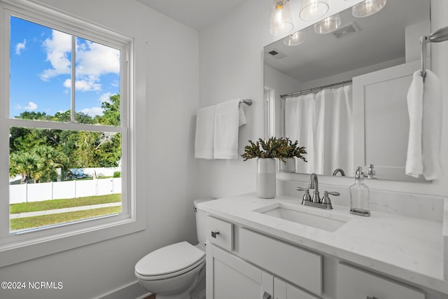 bathroom featuring a shower with curtain, visible vents, vanity, and toilet