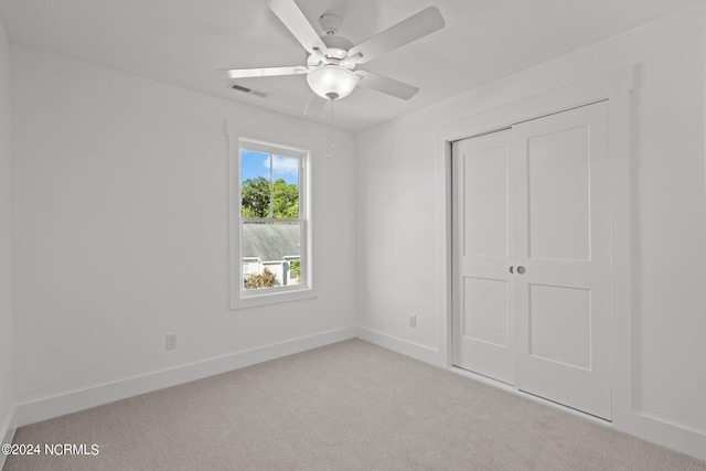 unfurnished bedroom with visible vents, baseboards, a ceiling fan, carpet, and a closet